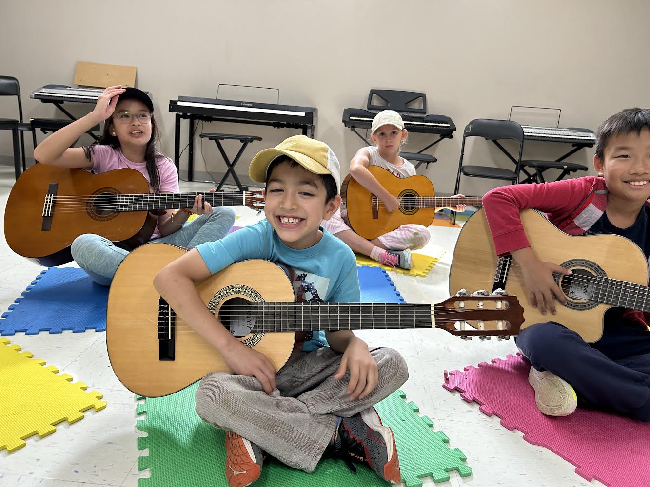 4 Smiling kids playing guitar together