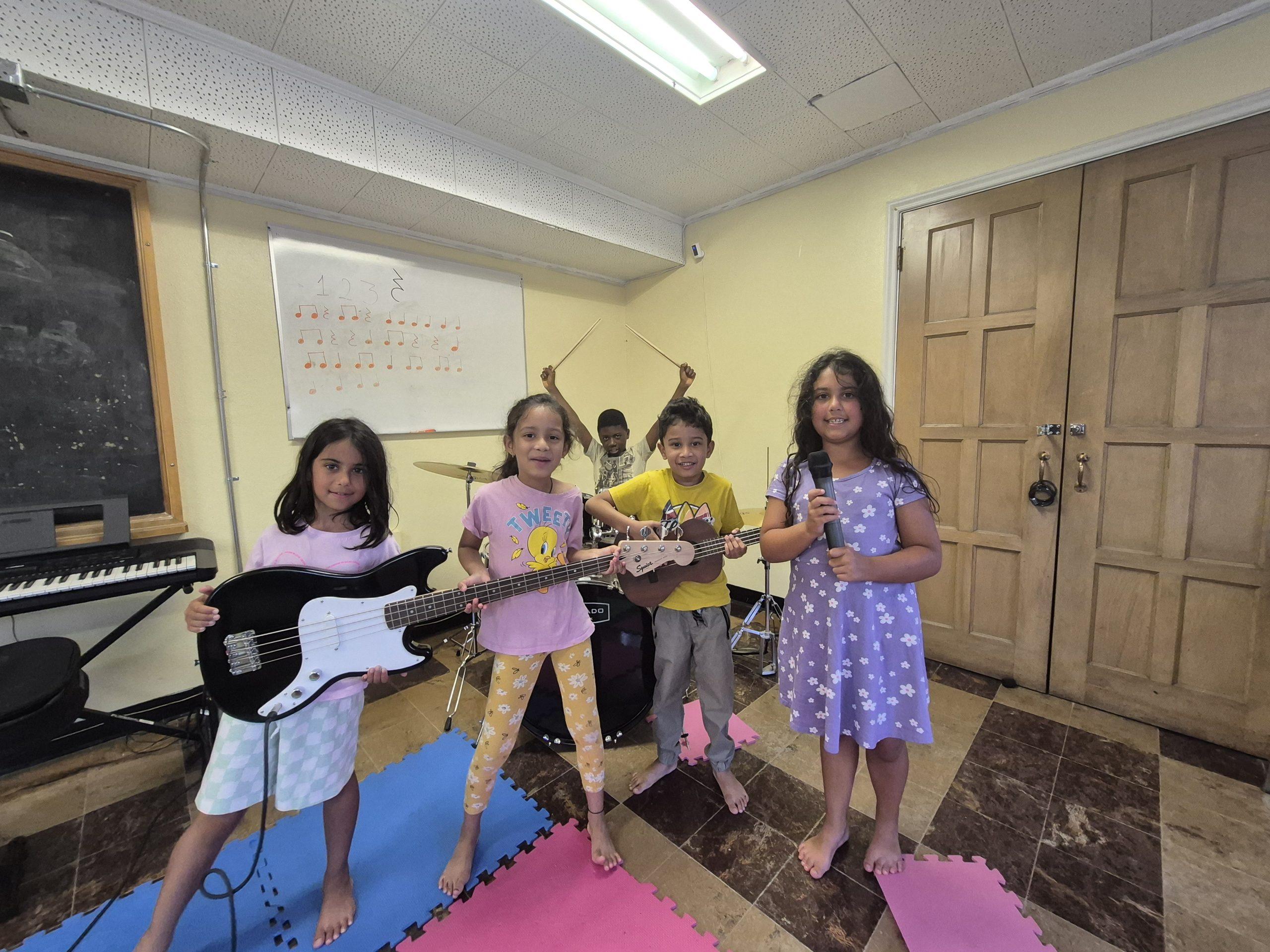 5 kids holding up their band instruments